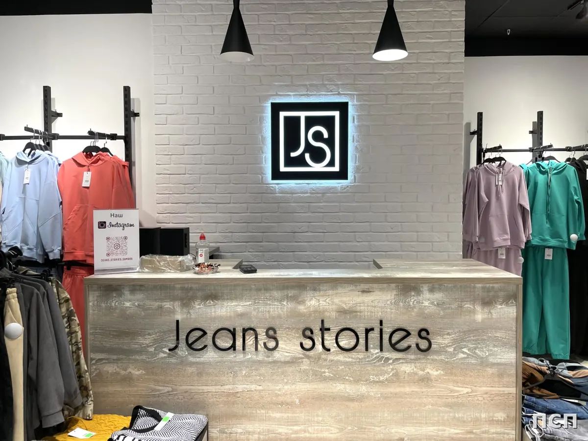 Оформление кассовой зоны магазина Jeans stories: световой знак и надпись на стойке