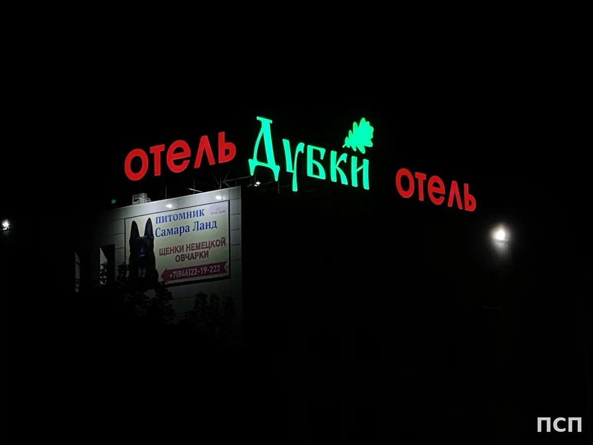 Световые буквы «Отель Дубки» на крыше ночью